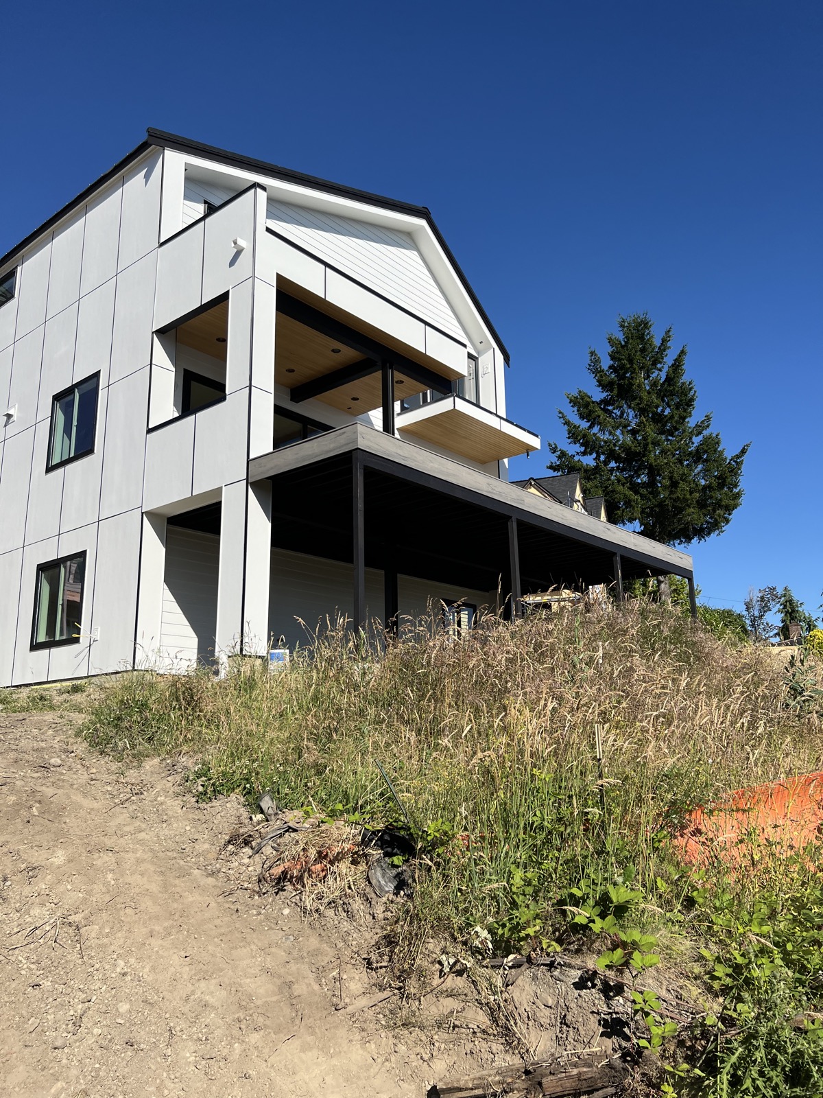 Modern white James Hardie panel home with cedar-accent covered deck, Browns Point, Tacoma
