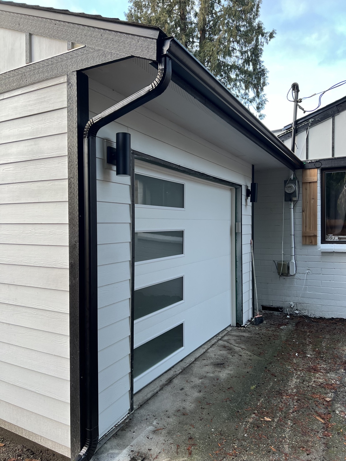 White board-and-batten siding with black trim and modern garage, Tacoma